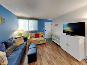 a living room with a couch and a flat screen tv at Villas Capri #9 in Fort Walton Beach