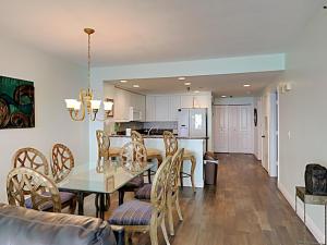 Un comedor y una cocina con mesa y sillas. en Emerald Isle #1506, en Pensacola Beach