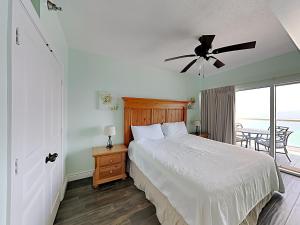 Un dormitorio con una cama y un ventilador de techo. en Emerald Isle #1506, en Pensacola Beach