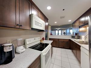 a kitchen with wooden cabinets and a stove top oven at Navarre Towers #203 in Navarre