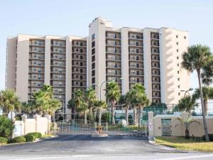 a large white building with palm trees in front of it at Navarre Towers #203 in Navarre