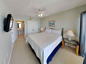 Un dormitorio con una gran cama blanca y un televisor. en Emerald Isle #304, en Pensacola Beach 15 fotos más