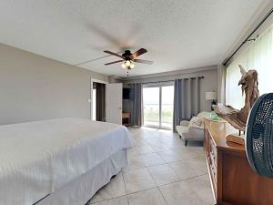 1 dormitorio con 1 cama y ventilador de techo en Regency Towers #205 West en Pensacola Beach