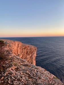 a cliff next to the ocean at sunset at House Mateja Unije in Unije