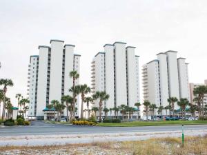a row of tall white buildings with palm trees at Summerwinds #204 in Navarre