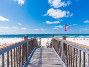 drewniana kładka prowadząca na plażę z amerykańską flagą w obiekcie Windemere #806 w mieście Perdido Key