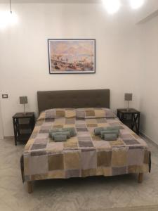Hipponion Suite في فيبو فالينتيا: غرفة نوم بسرير كبير مع مواقف ليلتين