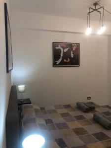 Hipponion Suite في فيبو فالينتيا: غرفة نوم بسرير وصورة على الحائط