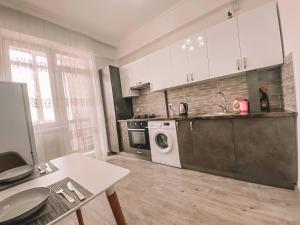 eine Küche mit Waschmaschine und Trockner in der Unterkunft Lovely Apartment in Sectorul Botanica