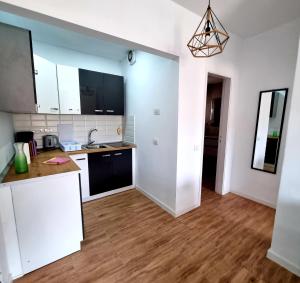 a kitchen with white cabinets and a wooden floor at Oasis in Los Cristianos
