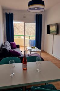 ein Wohnzimmer mit einem Tisch mit zwei Weingläsern darauf in der Unterkunft Oasis in Los Cristianos