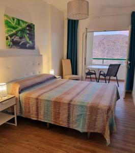 ein Schlafzimmer mit einem Bett, einem Tisch und Stühlen in der Unterkunft Oasis in Los Cristianos