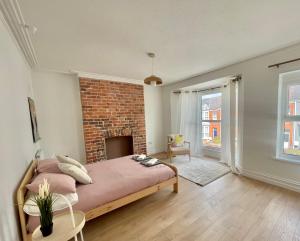a bedroom with a bed and a brick wall at Beautiful Family Home in the Heart of Swansea in Swansea