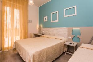 pokój hotelowy z 2 łóżkami i oknem w obiekcie Hotel Trieste w Cesenatico