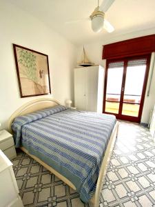 イスキアにあるISCHIA - PANORAMIC APARTMENT ON THE SEAのベッドルーム1室(青と白の掛け布団付きのベッド1台付)