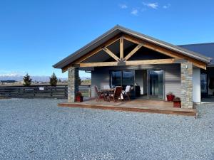 a house with a deck with a table and chairs at Uninterrupted Mountain Views in Twizel