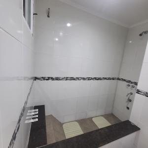 a bathroom with a white tiled shower with a bench at Apartamento Lo de Ana in Termas de Río Hondo