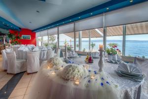 a room with a long table with white tables and chairs at Pansion Amigos in Podstrana