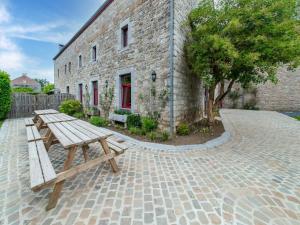 a wooden bench sitting in front of a brick building at Holiday home in Melreux-Hotton with sauna in Melreux