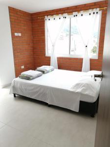 Cama en habitación con pared de ladrillo en Hermoso apartamento familiar con parqueadero privado, en San Gil