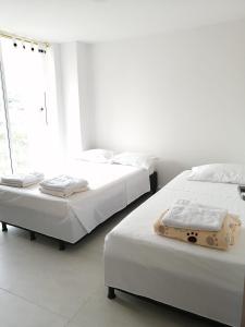 dos camas sentadas una al lado de la otra en un dormitorio en Hermoso apartamento familiar con parqueadero privado, en San Gil