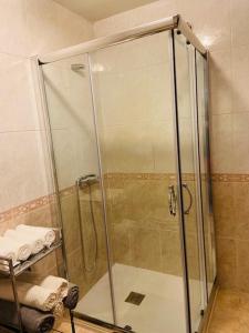 y baño con ducha y puerta de cristal. en APARTAMENTO HERRERIA, en Caldas de Reis