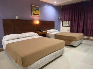 a hotel room with two beds and purple walls at BEST FORTUNE HOTEL at CHINATOWN in Manila