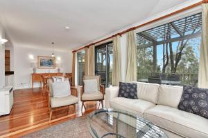 a living room with a white couch and chairs at Villa 2br Rose Villa located within Cypress Lakes Resort in Pokolbin