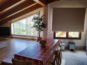 uma sala de jantar com uma mesa e uma planta sobre ela em Casa rural con vistas en el corazón del Pirineo em Los Molinos