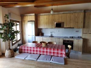 cocina con mesa y mantel rojo y blanco en Casa rural con vistas en el corazón del Pirineo, en Los Molinos
