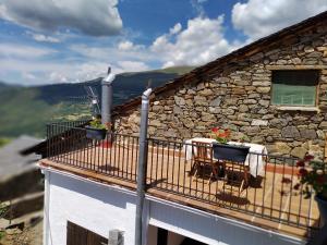 un balcone con tavolo e sedie su un edificio di Casa rural con vistas en el corazón del Pirineo a Los Molinos