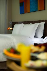 BH Raja Hotel في بيلو هوريزونتي: غرفة في الفندق بها سرير وصينية طعام