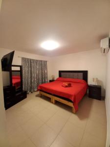 a bedroom with a red bed with a red blanket at hermosa casa en coto privado especial para ti y tu familia in Tepic