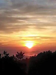 a sunset with the sun setting in the sky at RIVERSIDE PALM INN SG LEMBING in Sungai Lembing