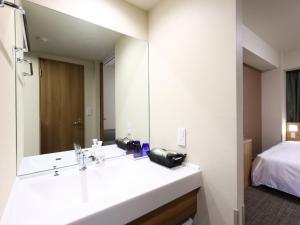 a bathroom with a sink and a mirror at Dormy Inn Express Fujisan Gotemba in Gotemba