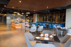 un restaurante con mesas y sillas y un bar en Grand Swiss-Belhotel Darmo en Surabaya