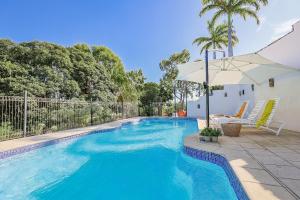 a large blue swimming pool with an umbrella and chairs at 1770 Sovereign Lodge Retreat in Seventeen Seventy