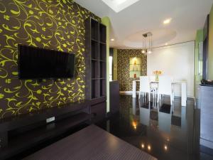 曼谷的住宿－Bella B All Suite Bangkok，客厅设有壁挂式平面电视。