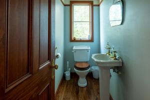 een badkamer met toilet, wastafel en raam bij 37 St James Avenue in Hanmer Springs +26 foto's