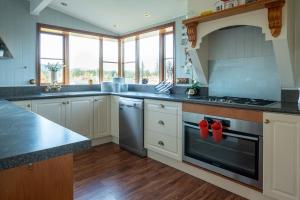 een keuken met witte kasten en een kookplaat oven bij 37 St James Avenue in Hanmer Springs