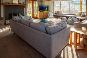 een woonkamer met een grote bank en een televisie bij 37 St James Avenue in Hanmer Springs