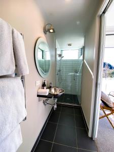 a bathroom with a sink and a shower at The Moorings Waterfront Picton in Picton