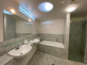 a bathroom with two sinks and a tub and a mirror at Couran Cove Resort Private Apartments, South Stradbroke Island, Gold Coast in South Stradbroke