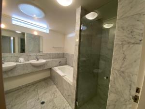 a bathroom with a shower and a sink and a mirror at Couran Cove Resort Private Apartments, South Stradbroke Island, Gold Coast in South Stradbroke