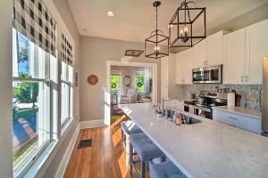 cocina con armarios blancos y encimera grande en Modern, Sun-Lit Retreat with Fire Pit and Yard!, en Jefferson City