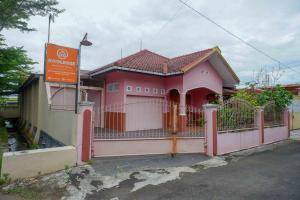 a pink house with a fence in front of it at KoolKost Syariah near Living Plaza Purwokerto (minimum stay 6 nights) in Purwokerto +11 photos