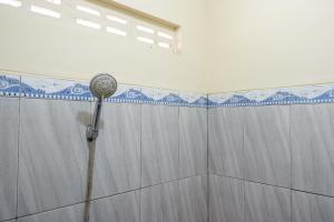 a shower with a shower head in a bathroom at KoolKost Syariah near Living Plaza Purwokerto (minimum stay 6 nights) in Purwokerto