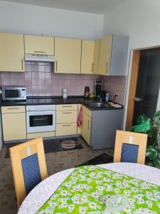 a kitchen with a table and two chairs and a table and a kitchen with at La Paula Wohnung für Monteure in Altenmedingen