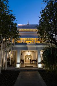 uma casa branca com uma mesa e cadeiras em Makka Hotel em Chiang Mai