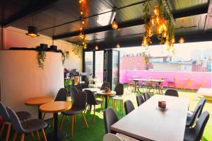 a restaurant with tables and chairs and pink walls at OYO Hostel Dongdaemun1 in Seoul